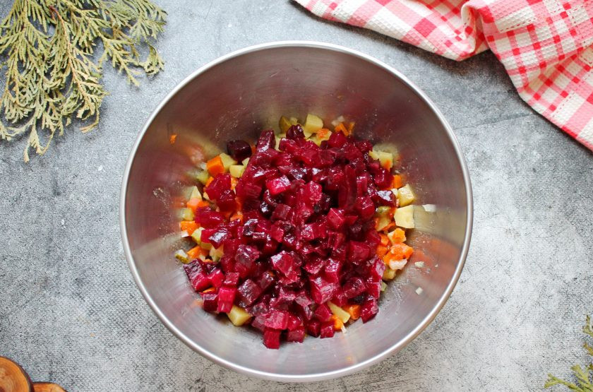 1. Этап. Винегрет с мидиями: Свеклу очистите, порежьте средним кубиком, влейте оставшееся растительное масло и перемешайте. Добавьте свеклу к овощам, посолите и перемешайте.