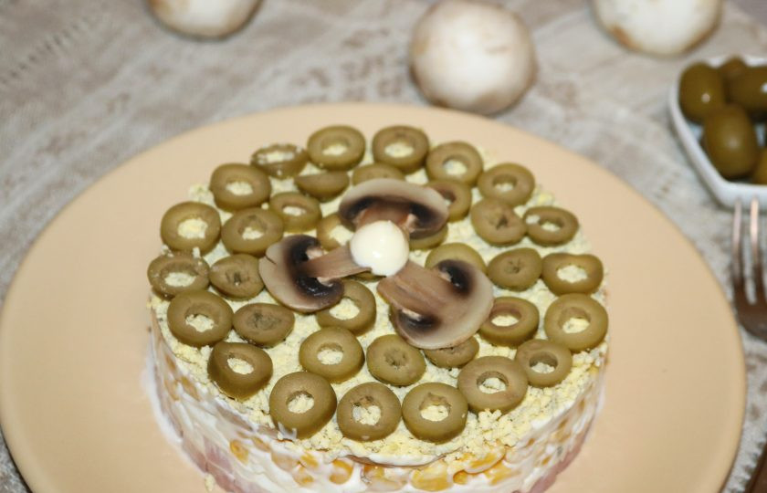 1. Этап. Слоёный салат с жаренными шампиньонами: Верх салата украсьте несколькими грибочками.