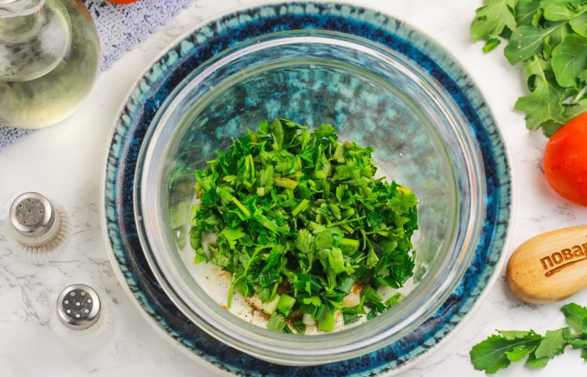 1. Этап. Белый соус со сметаной: Промойте петрушку или укроп, тщательно стряхните лишнюю влагу и измельчите зелень. Добавьте в емкость.