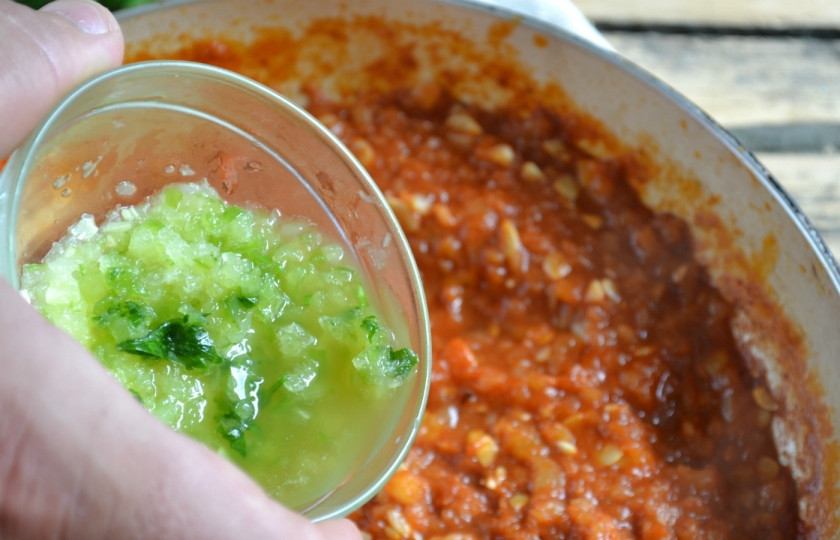 1. Этап. Аджика из кабачков с томатной пастой: Влейте в сотейник растительное масло и накалите его. Потом высыпьте смесь кабачков с томатной пастой, солью и сахаром. Тушите на медленном огне 30 минут. Затем добавьте молотый горький перец и пропущенный через пресс чеснок. Тушите еще 10-15 минут на слабом огне. За пять минут до конца готовки влейте уксус.