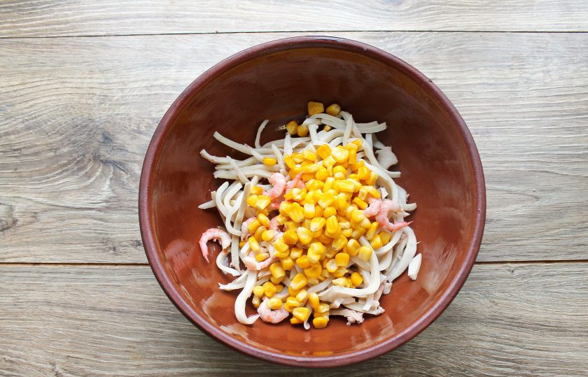 1. Этап. Салат с кальмарами, креветками и кукурузой: Добавьте в миску кукурузу.