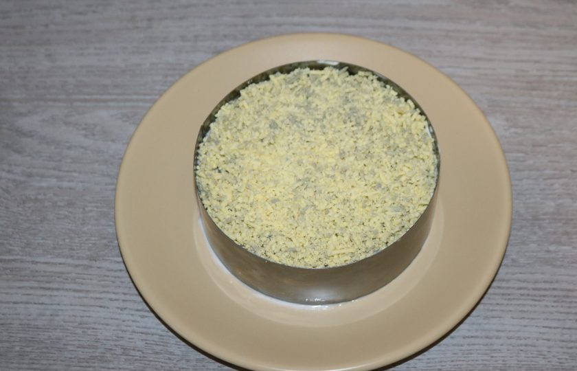 1. Этап. Слоёный салат с жаренными шампиньонами: Пятый слой - желток натёртый на мелкой тёрке.