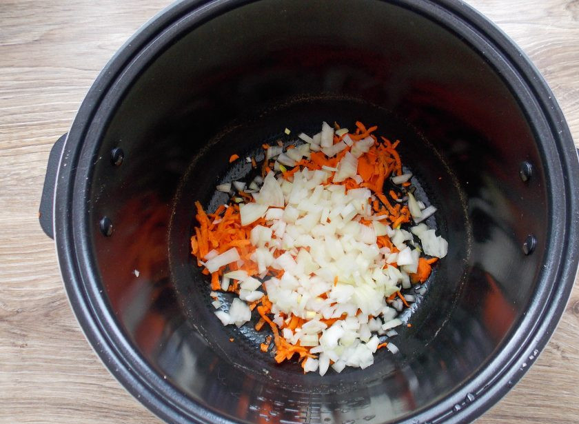 1. Этап. Говяжье сердце в мультиварке: Очистите лук и порежьте как вам больше нравится. Добавьте его в чашу к моркови.