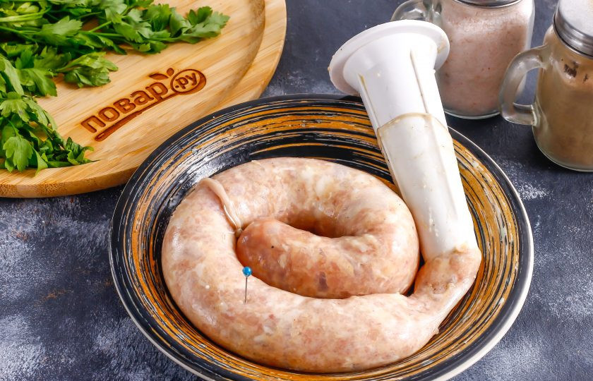 1. Этап. Куриная колбаса с салом: Промойте свиную чреву в воде, завяжите ее конец ниткой и пробейте иглой, чтобы выпустить воздух. Начините приготовленным фаршем, пробивая иглой места скопления воздуха и выпуская ее. Помните, что чреву нужно набивать не плотно, иначе она лопнет при варке. Затем завяжите конец кишки ниткой.