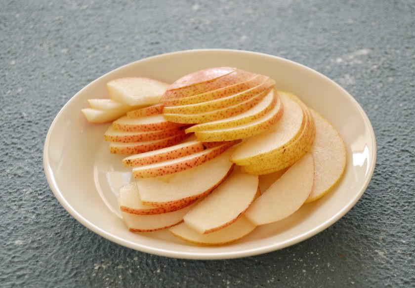 1. Этап. Салат с карамелизированной грушей: Разрежьте грушу пополам, удалите сердцевину и косточки. Затем нарежьте грушу вдоль на тонкие ломтики.