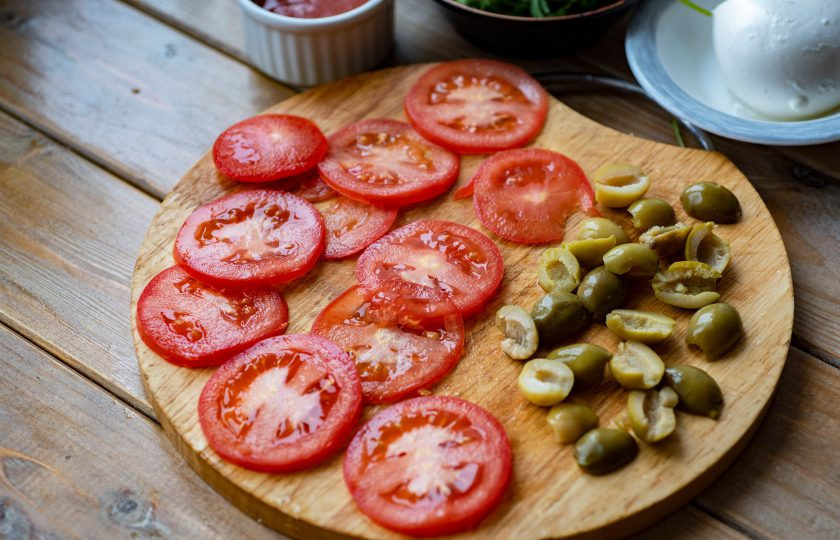 1. Этап. Пицца с оливками и креветками: Помидоры нарежьте тонкими кружочками, оливки каждую разрежьте на 2 части.