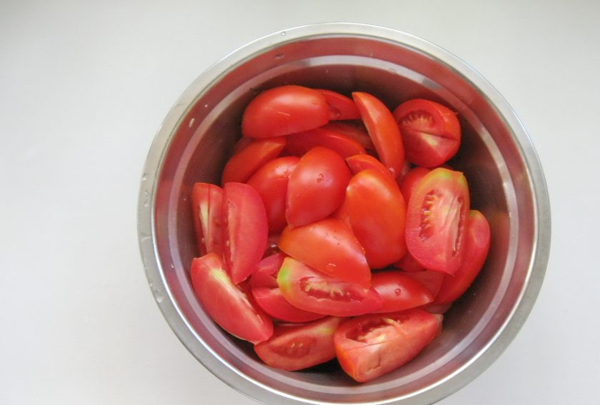 1. Этап. Томатный морс на зиму: Нарежьте помидоры половинками и удалите место прикрепления плодоножки.