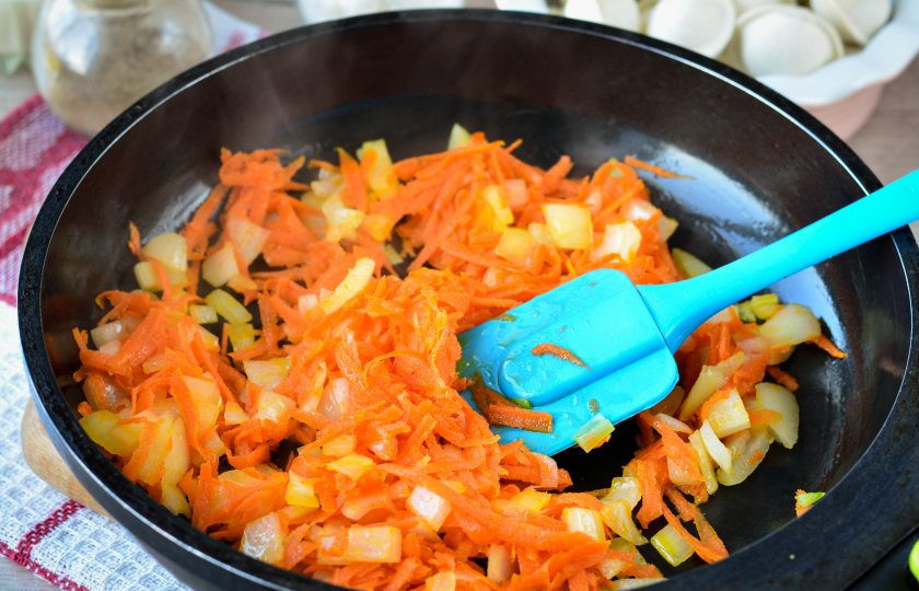 1. Этап. Пельмени тушеные с морковью и луком: Пассеруйте овощи на небольшом огне 2-3 минуты до мягкости, помешивая.