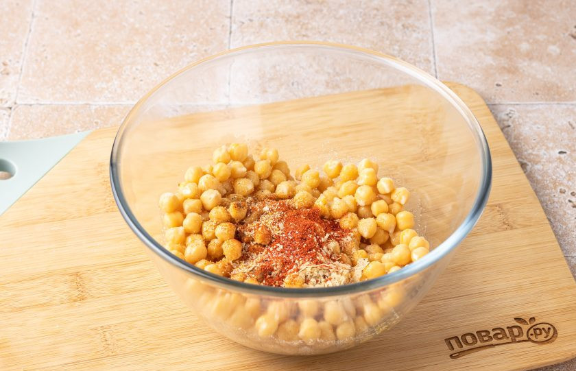 1. Этап. Хрустящий нут в духовке: Переложите нут в тарелку, добавьте все специи, соль и оливковое масло. Перемешайте.