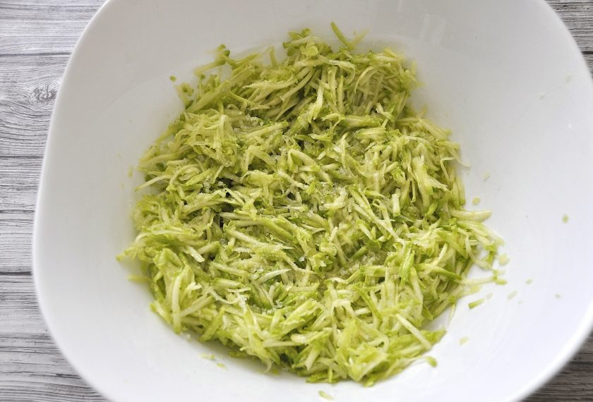 1. Этап. Кабачковые оладьи без муки: Если кабачок молодой и кожура у него нежная, то можно сразу натереть его на терке, не очищая. Посолите, перемешайте, подождите примерно 3 минуты, чтобы выделился сок.