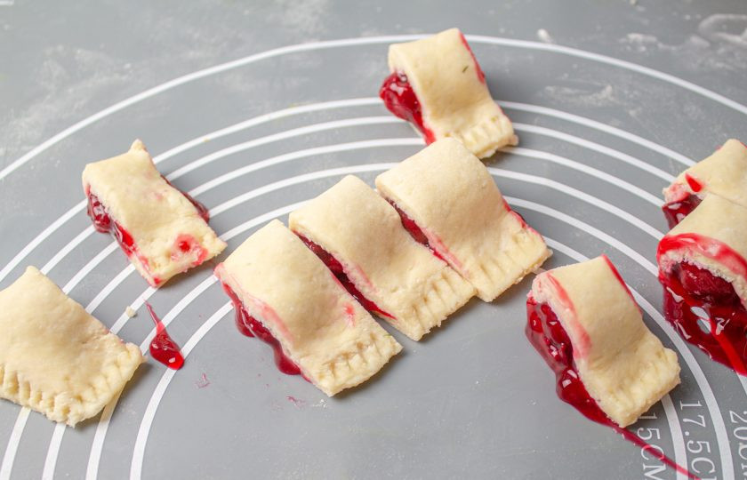 1. Этап. Творожные рогалики с вишней: Разрежьте получившийся рулет на небольшие рулетики шириной по 3-4 см. Переложите все заготовки на противень, выстеленный пергаментом и выпекайте в заранее разогретой духовке до 180 градусов 20-25 минут.