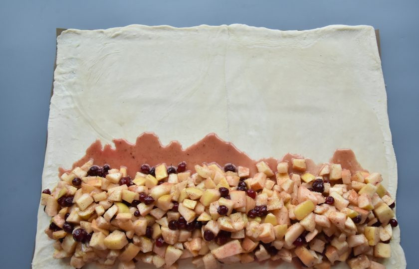 1. Этап. Штрудель с яблоками и брусникой: Выложите начинку горкой по длинному краю раскатанного теста.