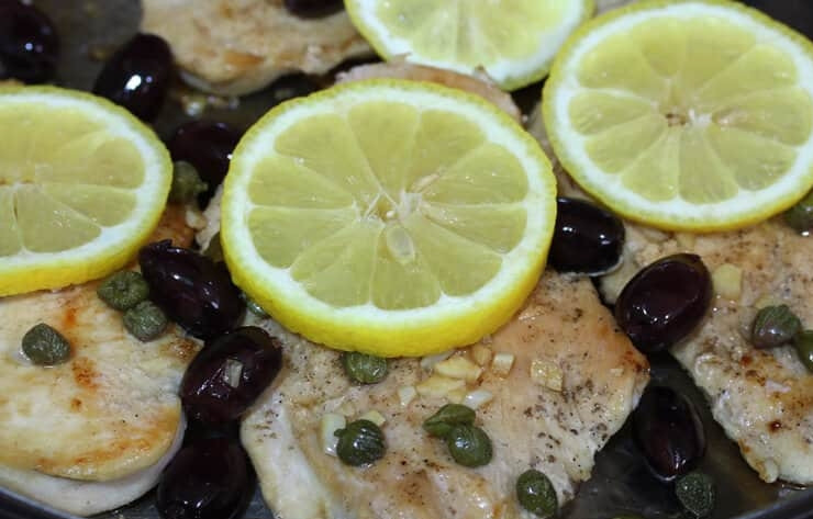 1. Этап. Куриная грудка с лимоном на сковороде: 4. Выложите в соус кусочки мяса, выложите вокруг оливки и каперсы. Нарежьте лимон кусочками и выложите на курицу.