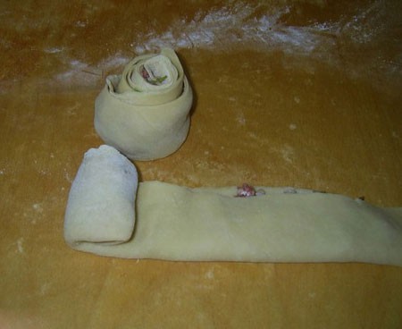 1. Stage. Dumplings Rosettes: Fold the dough in half and roll it with the ends clamped in the middle.