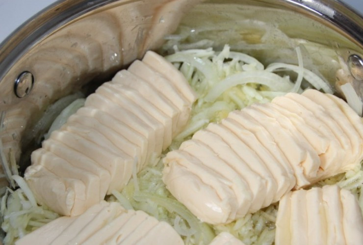 1. Этап. Запеканка из кабачков с манкой: Далее мы отжимаем тертые кабачки от сока и перекладываем их в кастрюлю, добавляем оливковое масло, репчатый лук и плавленый сыр, ставим кастрюлю на медленный огонь.