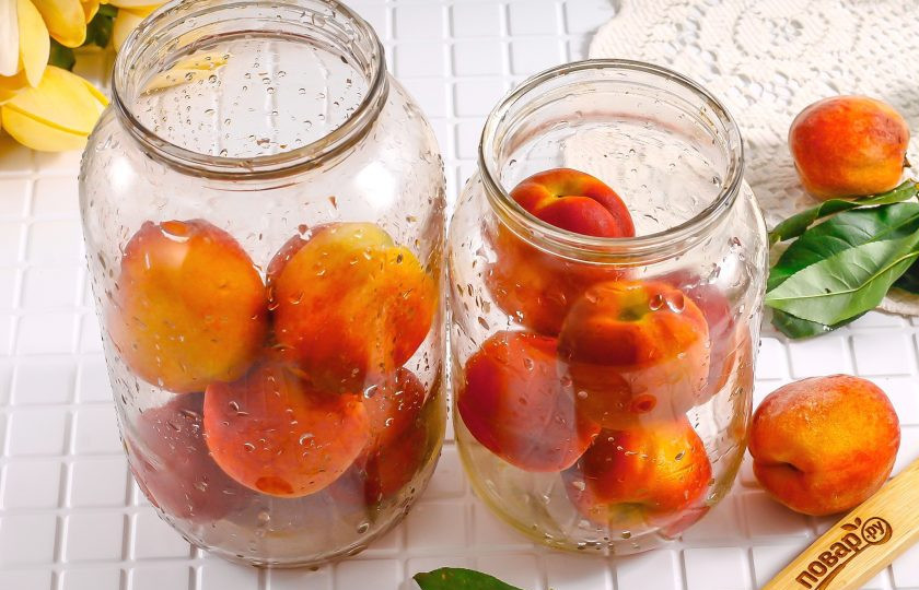 1. Этап. Компот из персиков с косточкой на зиму: Персики и банки тщательно промойте, высыпьте плоды в банки примерно на две трети.
