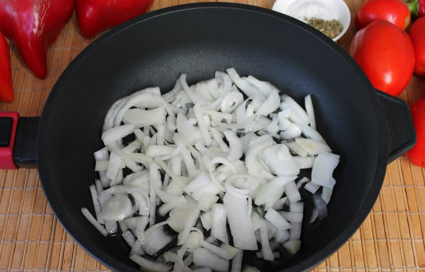 1. Этап. Салат из сладкого перца и помидоров на зиму: В сотейник с растительным маслом высыпаем нарезанный лук и отправляем на огонь.