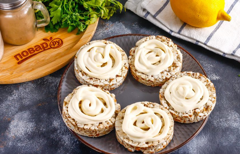 1. Этап. Бутерброды к шампанскому: Овсяные хлебцы или другую основу для бутербродов обмажьте майонезом любой жирности или плавленым сыром, сливочным маслом и т.д. Выложите их на тарелку.