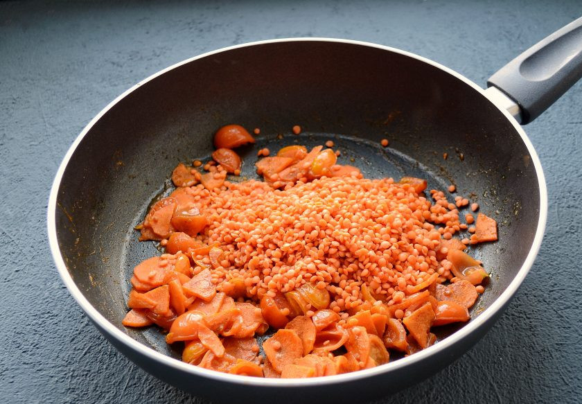 1. Этап. Дал из красной чечевицы: Промойте чечевицу, добавьте её на сковороду. Перемешайте, пару минут продолжайте обжаривать.