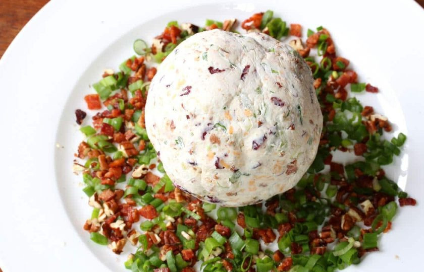 1. Этап. Колобки Три сыра: Достаньте колобки из холодильника и обваляйте каждый в кусочках бекона и зеленого лука.