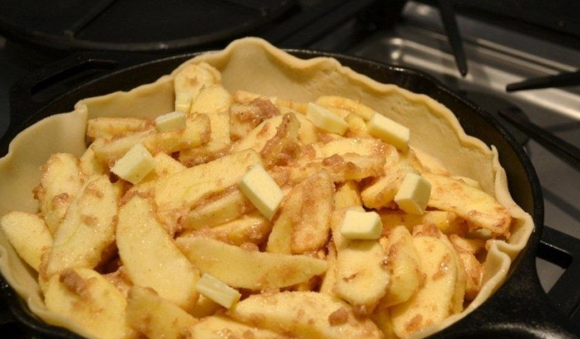 1. Этап. Быстрый рецепт яблочного пирога: 6. Выложите внутрь яблочную начинку, оставшееся сливочное масло нарежьте кусочками и распределите.