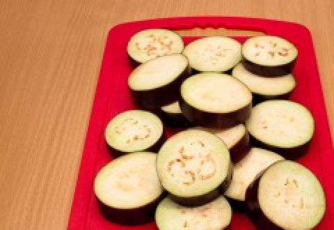 1. Этап. Баклажаны запеченные с томатами и сыром: 1. Толстыми кружочками нарежьте баклажаны.