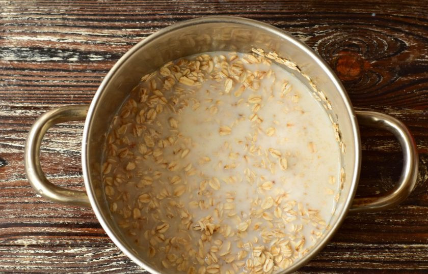 1. Этап. Овсяное суфле: В кастрюлю выложите овсяные хлопья, влейте молоко, и сразу же добавьте сахар.