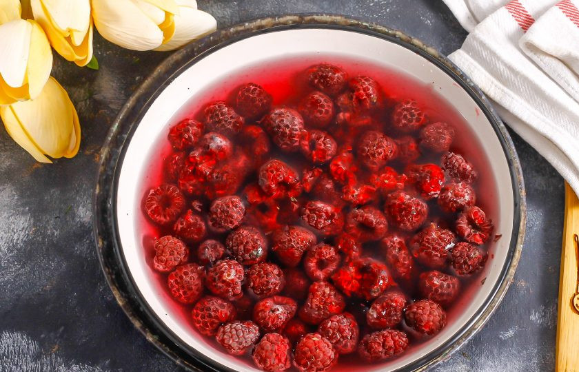 1. Этап. Силт из малины на зиму: Выложите ягоды в глубокую емкость и влейте воду, промойте малину.