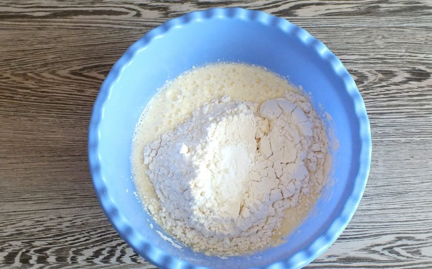 1. Этап. Кекс с клюквой на сметане: Всыпьте муку, разрыхлитель. Перемешайте тесто миксером.