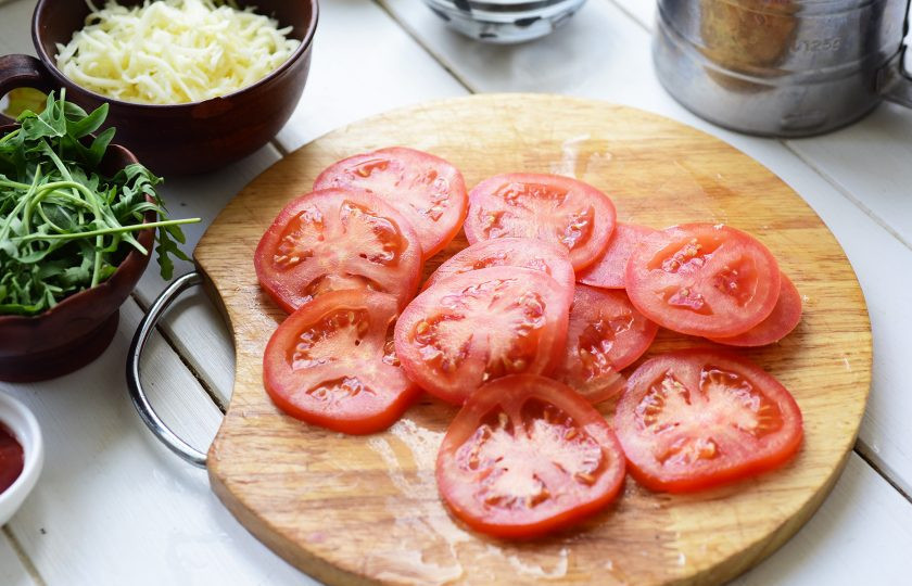 1. Этап. Пицца на сухом молоке: Помидоры нарежьте тонкими кружочками.