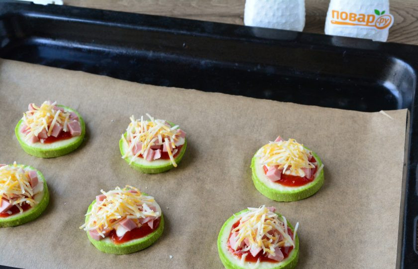1. Этап. Мини-пиццы из кабачков: Присыпьте каждый кружок кабачка тертым сыром.