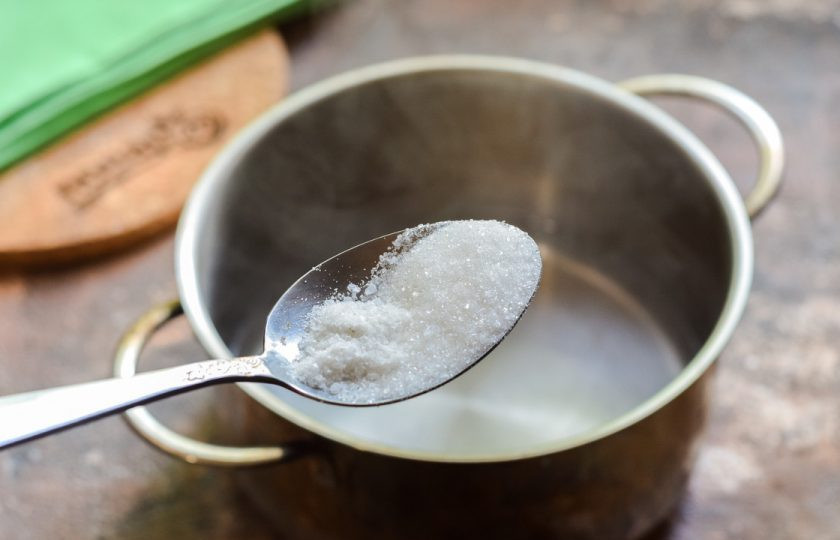 1. Этап. Огурцы с крыжовником на зиму: Последний раз слейте воду в кастрюлю, добавьте соль и сахар, проварите минуту, добавьте уксус, снимите с огня.