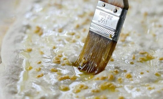 1. Этап. Пицца с беконом и артишоками: 2. Затем растяните его в форме овала или круга. Смажьте тесто маслом. Сверху натрите моцареллу. Отправьте основу на 10 минут в духовку при 180 градусах.