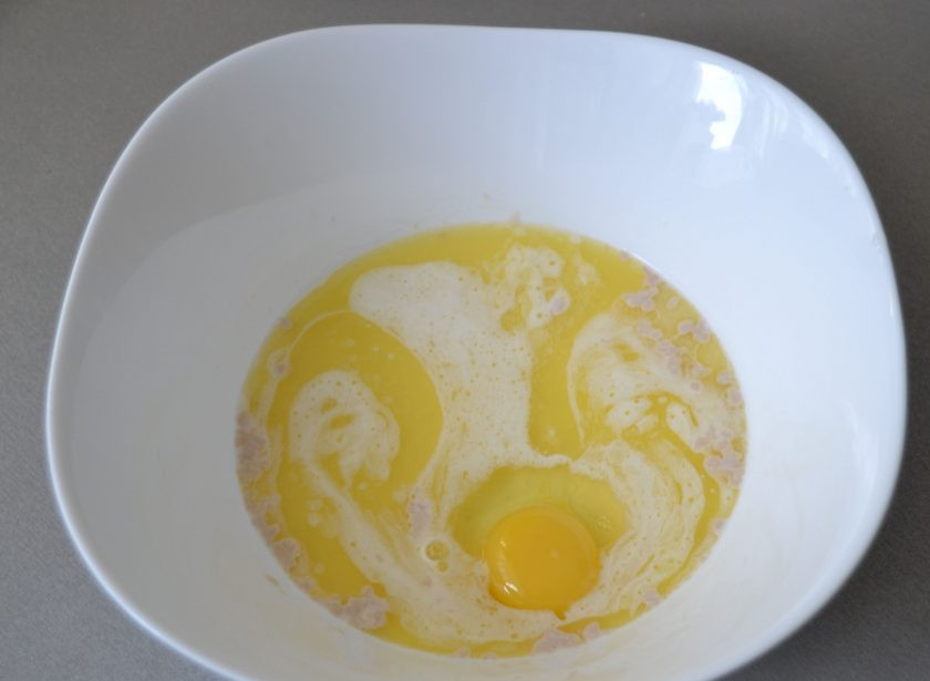 1. Этап. Булочки Бухтельн: Вбейте 1 яйцо, добавьте растопленное сливочное масло.