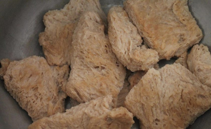 1. Этап. Соевый шницель: Час прошел, и мы продолжаем. На плите разогреваем сковороду с растительным маслом. Выкладываем на нее кусочки сои для обжарки (не выливайте воду, в которой они отмачивались). Обжариваем соевые шницели с двух сторон до румяности, они чем-то будут напоминать хлебные куски. Перекладываем их после обжарки в глубокую кастрюлю (объемом не менее 4-ех литров).