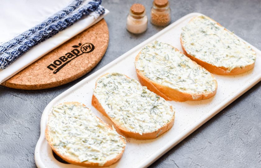 1. Этап. Бутерброды с красной икрой: Ломтики батона смажьте сливочным крем сыром с зеленью. При желании вы можете батон подсушить на гриле или в духовке.