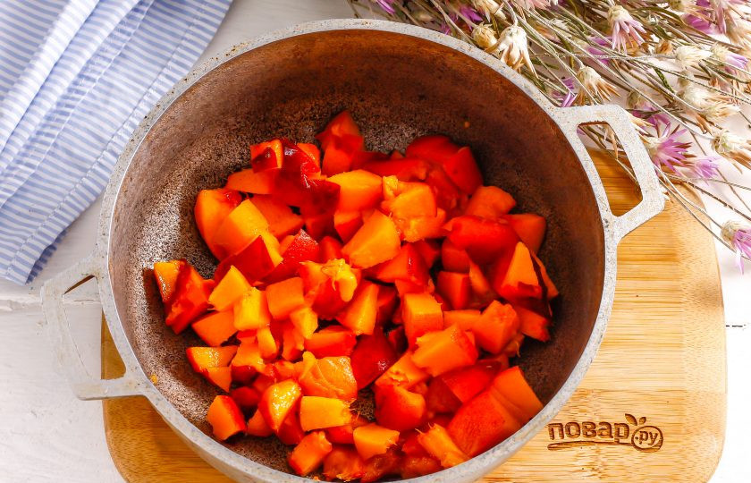 1. Этап. Персиковый компоте для торта: Персики промойте в воде, удаляя ворсистый слой на поверхности фруктов. Нарежьте их мелкими кубиками в казан или другую емкость, удаляя косточки.