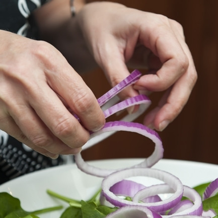 1. Этап. Салат со шпинатом и беконом: 3. Очистите луковицу и нарежьте тонкими кольцами. Кольца разделите и добавьте в миску к шпинату.