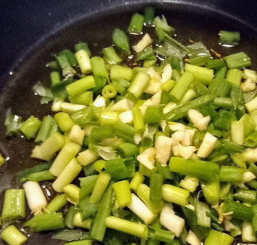 1. Этап. Салат с необычным соусом Зелёная богиня: В глубокой ёмкости на среднем огне разогреть масло и добавить лук зелёный, чеснок и имбирь. Готовить, помешивая, минут 5 до размягчения лука, но не до потери им цвета.