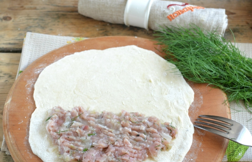 1. Этап. Чебуреки с мясом: Тесто разделите на 8 частей. Каждую часть раскатайте в форме круга как можно тоньше. На половину круга положите начинку, отступая от краев примерно 1,5 см.