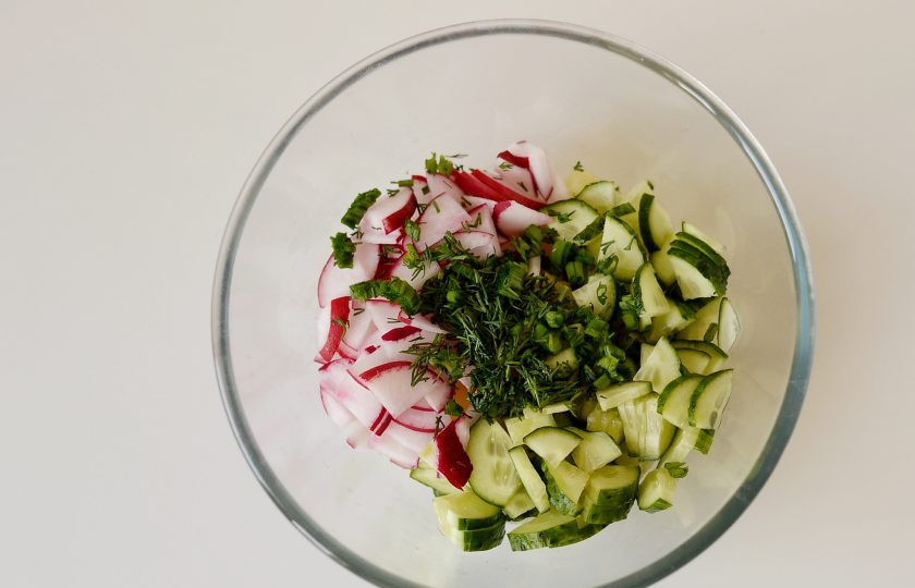 1. Этап. Салат с кукурузой, грибами и огурцами: Редис и огурец нарежьте четвертинками, зелень мелко порубите ножом.