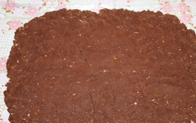 1. Этап. Рулет Mинутка из печенья: Расстилаем на столе пищевую пленку или пекарскую бумагу и выкладываем на нее тесто, раскатываем его в прямоугольный пласт.