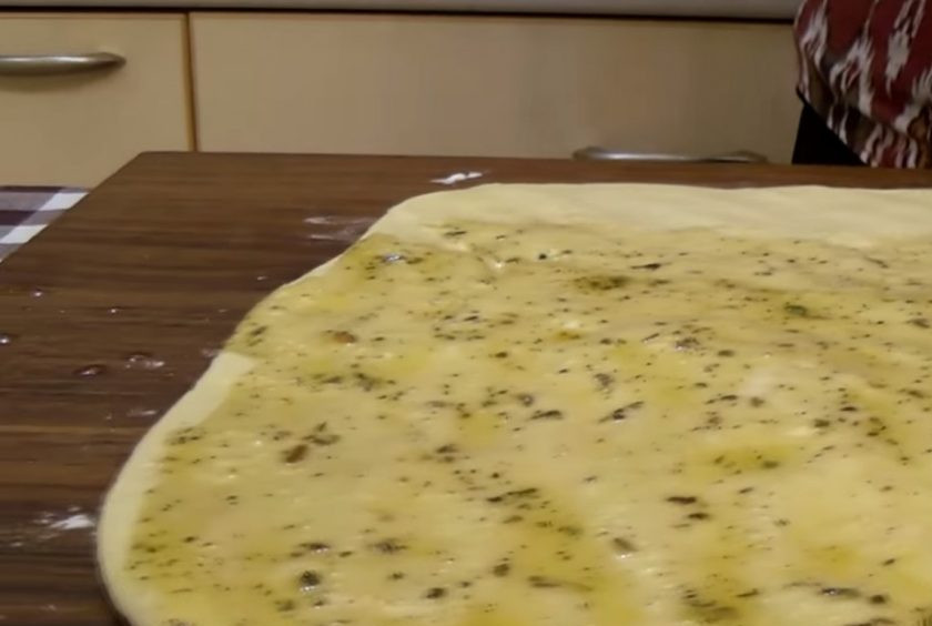 1. Этап. Хлеб спиральный: 2. Накройте миску пленкой и оставьте при комнатной температуре на 1 час. Оставшееся оливковое масло смешайте с прованскими травами и сушеным чесноком. Тесто раскатайте в пласт толщиной 1 см и смажьте масляной смесью.