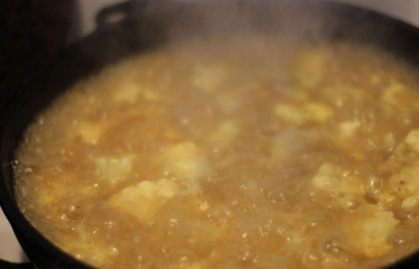 1. Этап. Рисовая запеканка с цветной капустой и сыром: Далее уменьшить огонь, содержимое сковородки залить водой, посолить и накрыть крышкой.