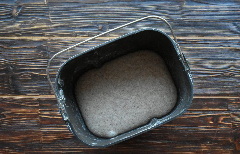 1. Этап. Цельнозерновой хлеб на закваске в хлебопечке: После того как закончится процесс замеса, извлеките ведерко с тестом из устройства. Извлеките лопактку для замеса. Тесто сложите конвертом, округлите заготовку и выложите обратно в емкость. Поставьте ведерко с тестом в холодильник для подъема. Можно оставить тесто подходить при комнатной температуре, тогда процесс созревания пойдет быстрее.