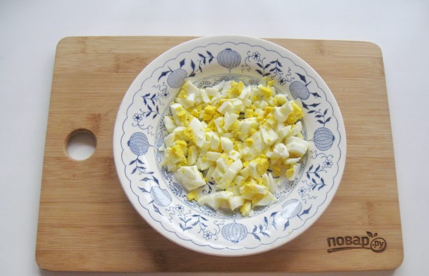 1. Этап. Салат-коктейль с крабовыми палочками: Яйца сварите вкрутую, охладите, очистите и мелко нарежьте.