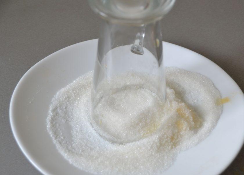 1. Этап. Безалкогольный глинтвейн на гранатовом соке: Опустите смазанный апельсиновым соком ободок бокала в сахарный песок.