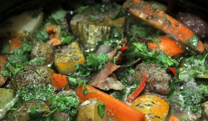 1. Этап. Говядина в чугунке в духовке: На мясо выложите лук, морковку, сельдерей, помидоры, перец острый и все остальные овощи. Потом картошку посолите и поперчите, добавьте специи по вкусу. Сверху выложите кусочки бекона. Теперь смешайте бульон с вином, доведите до кипения. Смесь вылейте в чугунок. Ее должно хватить, чтобы покрыть полностью мясо и картошку. Вот такой 