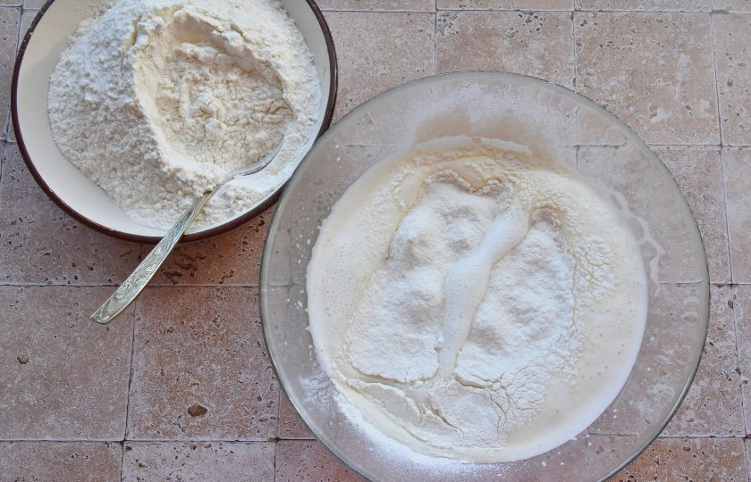 1. Этап. Дутые оладьи: Просейте муку через мелкое сито. Частями введите муку в тесто, полностью вмешивая каждую порцию.