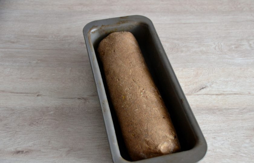 1. Этап. Хлеб Земгальский: Выложите заготовку хлеба в форму для выпекания, огладьте его руками, смоченными водой. Накройте салфеткой и оставьте на расстойку при комнатной температуре на 1 час.